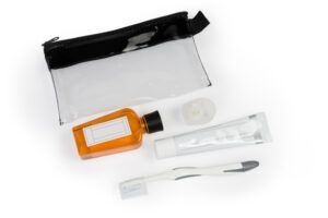 Men's plastic travel toiletry bag and toiletry kit for oral hygiene on a light background, top view